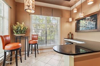 A kitchen with a bar area and two chairs.